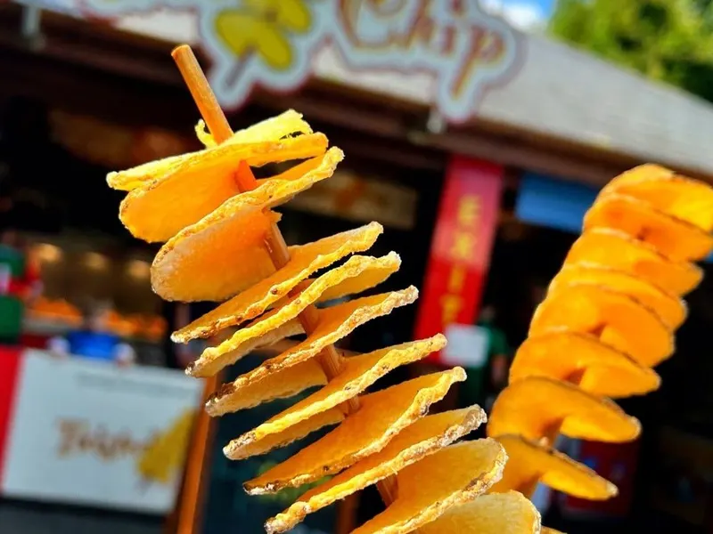 A twisted potato chip on a stick in front of the Twisted Chip stall